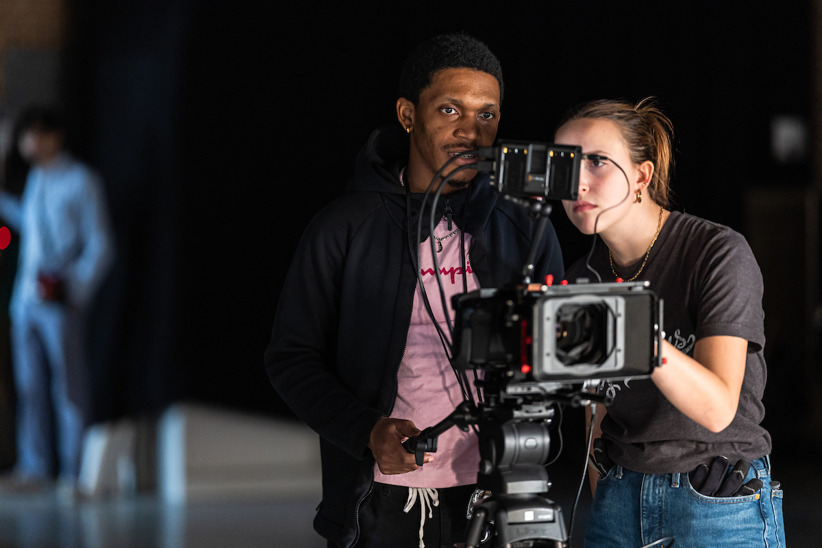 Student and professor working with camera for cinematography class 