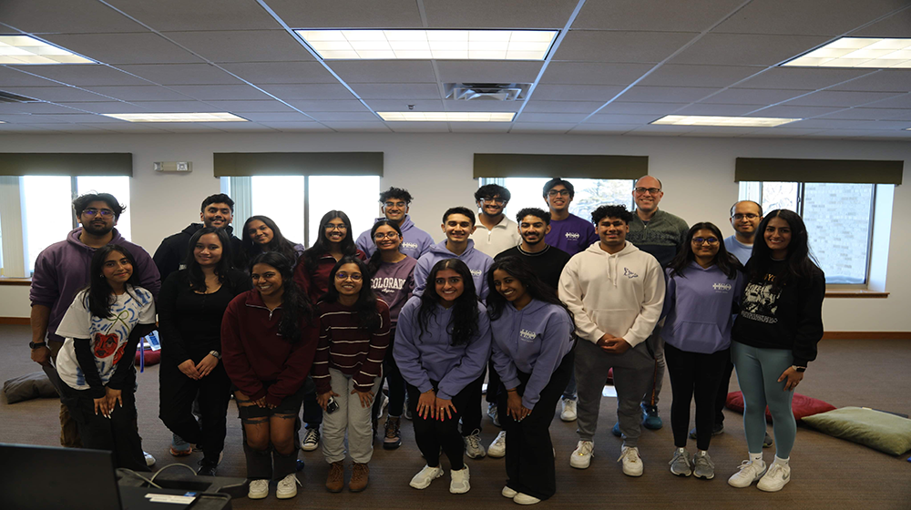 Group of students clustered together smiling