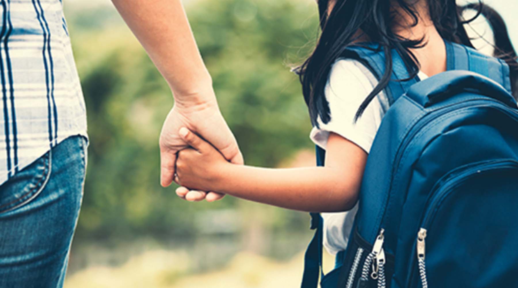 child holding hands with adult