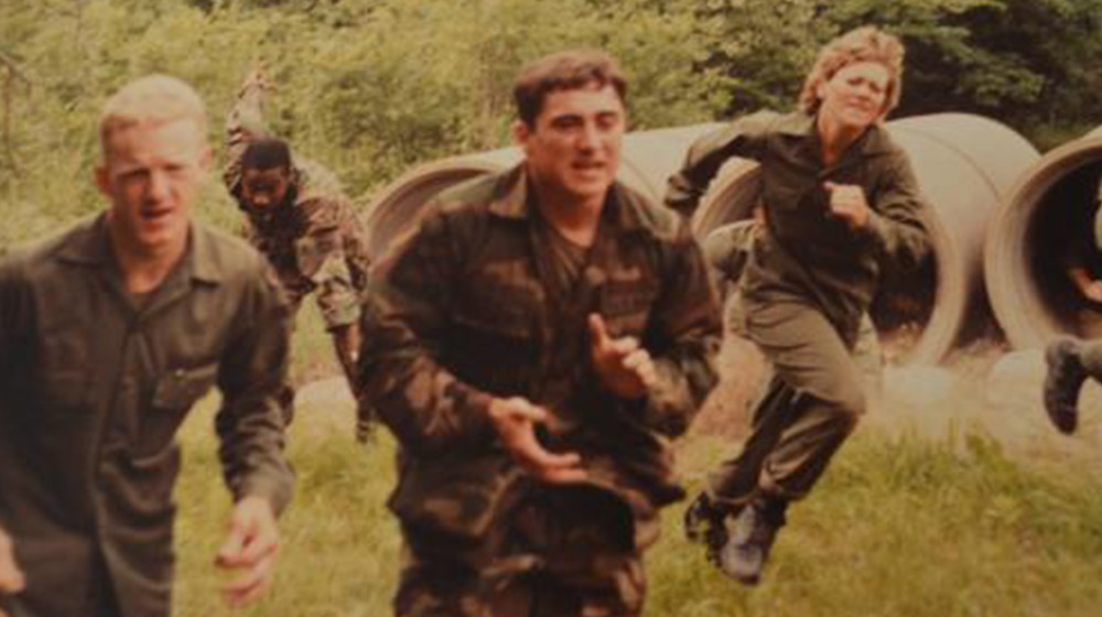 Loyola University Chicago ROTC students complete in a training exercise out in the field. They are outside running in a field.