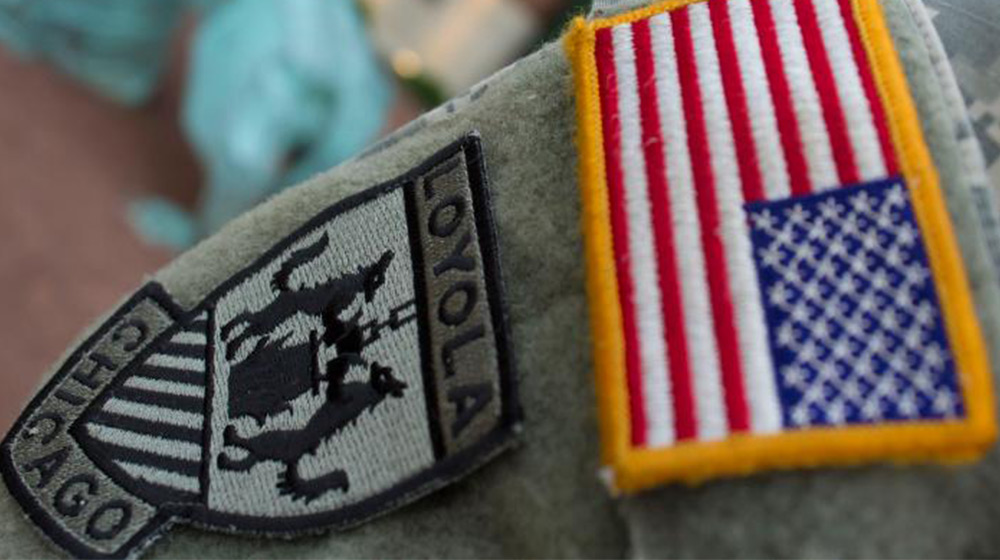 A close up of a Loyola University Chicago ROTC patch and American flag patch on a student's uniform