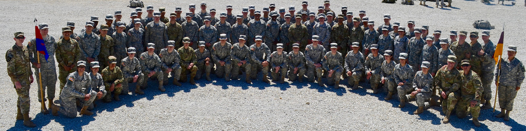 A large group photo of Loyola University Chicago ROTC students. Some are kneeling and others are standing posed for the photo in uniforms.