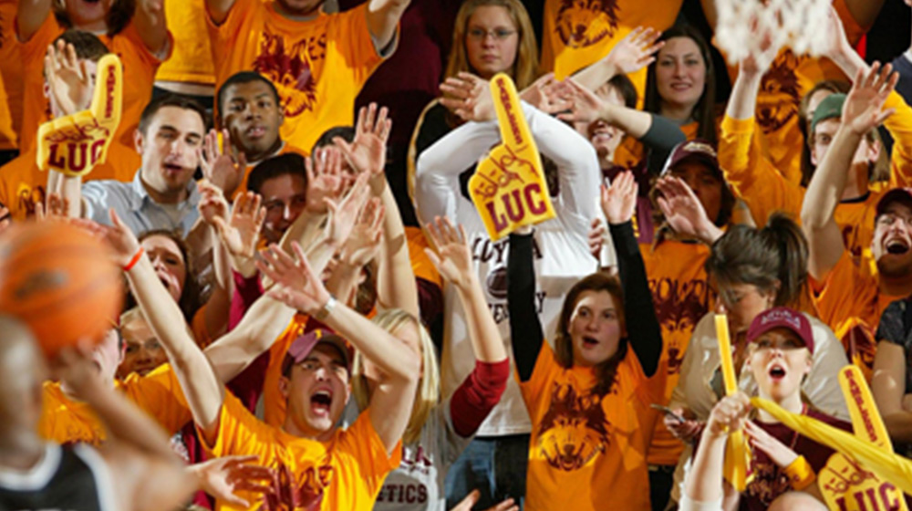 A large crowd of Loyola University Students cheering at a sporting event.