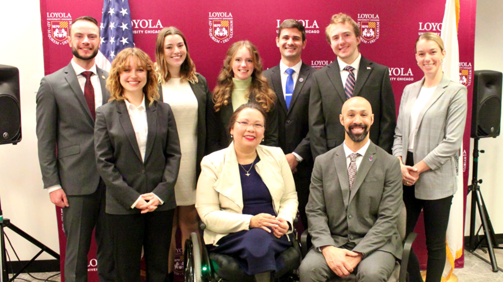 Loyola University Chicago Office for Military Veteran Student Services pose in formal wear for a group photo with US senator Tammy Duckworth